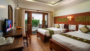 A hotel room with two beds, a TV, a desk with a chair, and a view of greenery outside. - ChampeySor Angkor Boutique Hotel (Siem Reap)