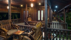 A wooden deck with seating and a table, surrounded by a railing. - ChampeySor Angkor Boutique Hotel (Siem Reap)