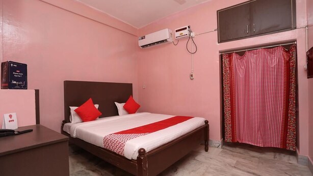 A bedroom with a bed, a desk, an air conditioning unit, and a wardrobe. - Chilika Residency (Bhubaneshwar)