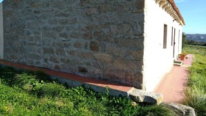 A stone building with a tiled roof and a small porch. - The way of "li mizzani" la jaceta (Palau)
