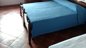 A bedroom with a wooden bed, a wardrobe, a window, and a mirror on the wall. - The way of "li mizzani" la jaceta (Palau)
