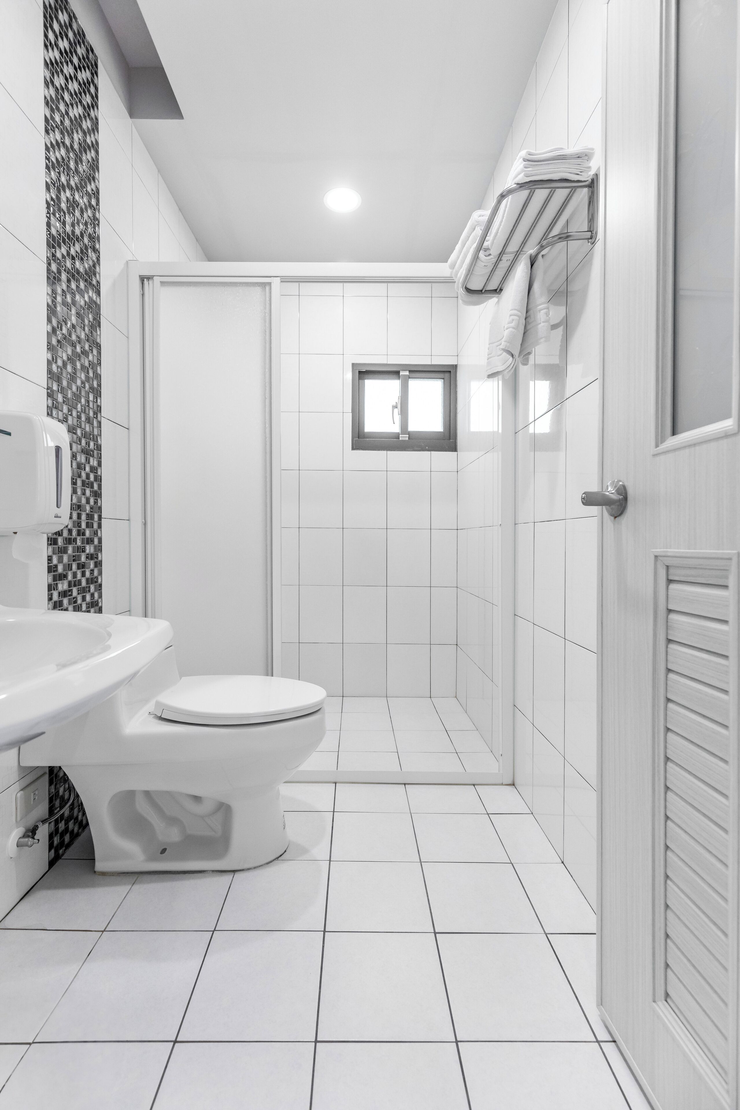 A modern bathroom with a toilet, sink, and shower area.