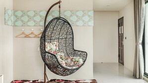 A modern interior with a hanging chair, a coat rack, and a patterned wall. - Summer Crazy (Magong)