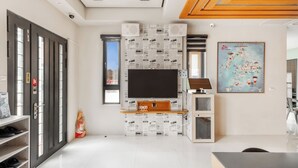 A modern living room with a flat-screen TV, built-in speakers, and a map on the wall. - Summer Crazy (Magong)