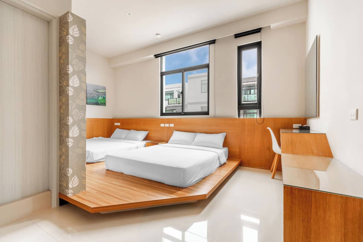 Ein modernes Hotelzimmer mit einem hölzernen Bett, einem Schreibtisch und einem großen Fenster mit Blick auf die Stadt.