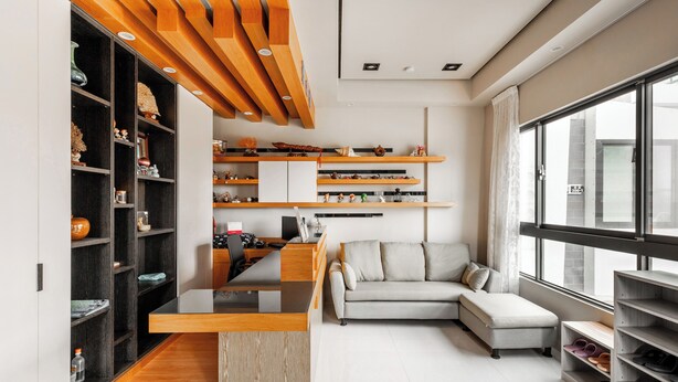 A modern living room with a sofa, a coffee table, and a desk with a computer. There are shelves with decorative items and a shoe rack. - Summer Crazy (Magong)
