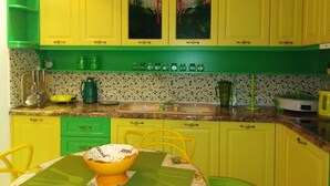Una cucina con mobili gialli, un piano di lavoro verde e una ciotola sul tavolo.