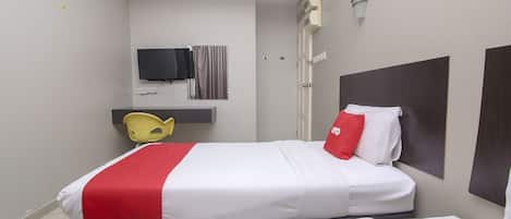 A hotel room with two beds, a TV, a mirror, and a small desk with a chair.