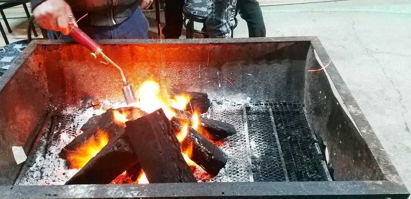 Uma grelha de metal com carvão em brasa.