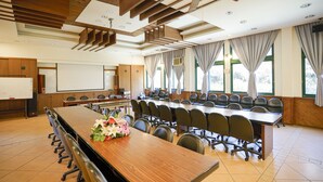 A conference room with a long table, chairs, a whiteboard, and a ceiling fan. - Cloud Falls Resort (Ren'ai)