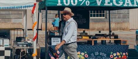 A street food vendor with a green tent advertising 100% vegan options.
