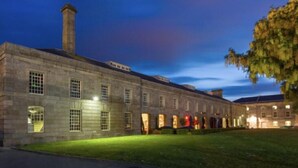 A historic building with a long facade, multiple windows, and a prominent chimney. - RWY Suite48 (Plymouth)