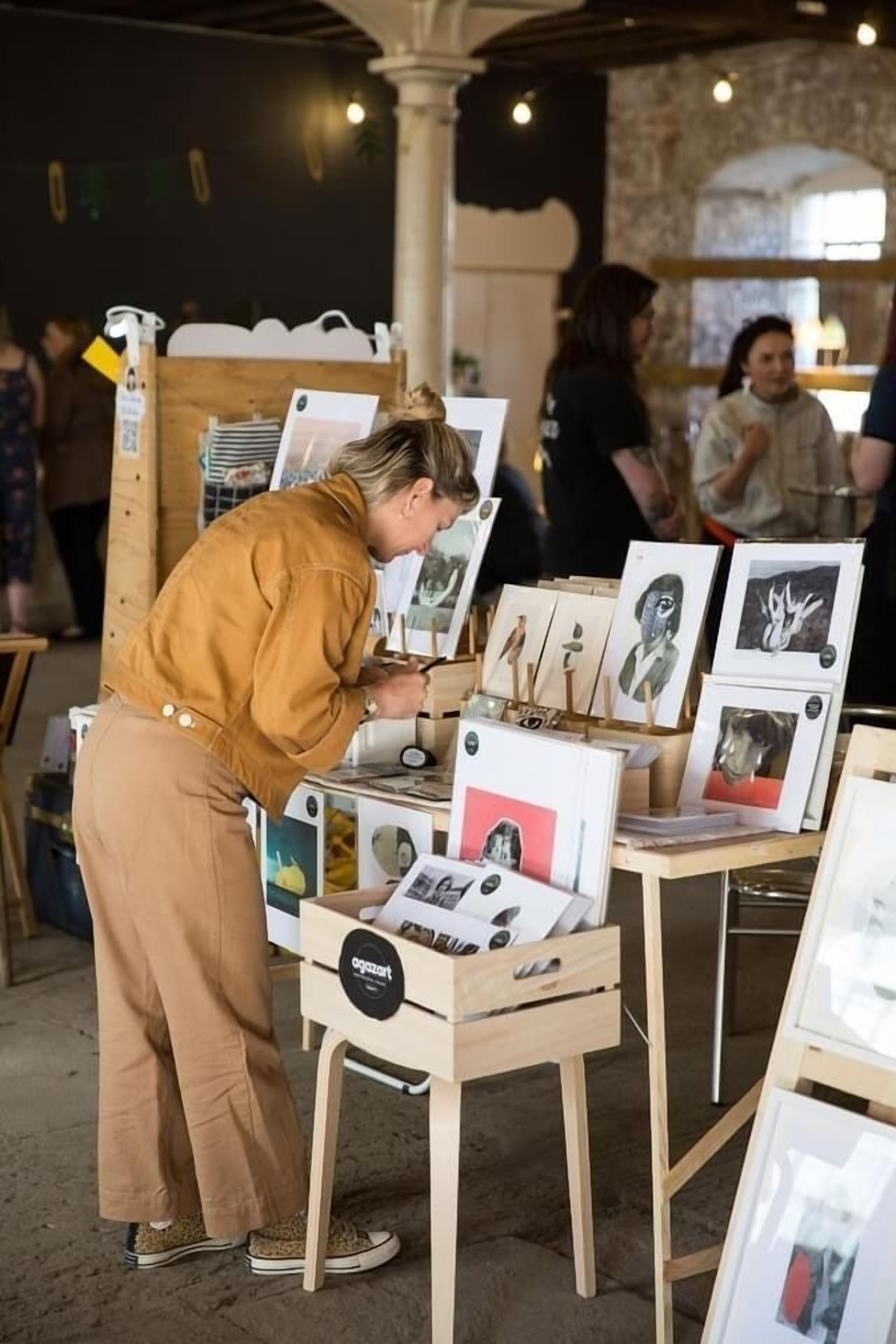 A person examining artwork at an indoor exhibition.