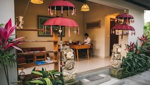 A traditional interior with a wooden desk, shelves, and a statue. - The Runik Ubud (Ubud)