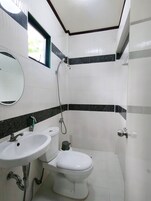 Un baño con inodoro, lavamanos y ducha.