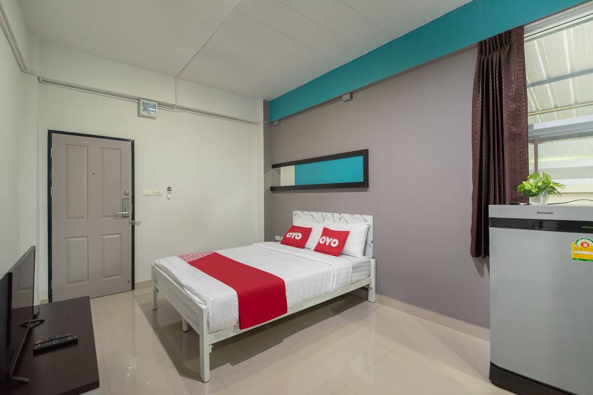 Une chambre d’hôtel équipée d’un lit, d’une télévision, d’un bureau et d’un réfrigérateur.