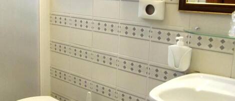 A bathroom with a toilet, bidet, and sink.