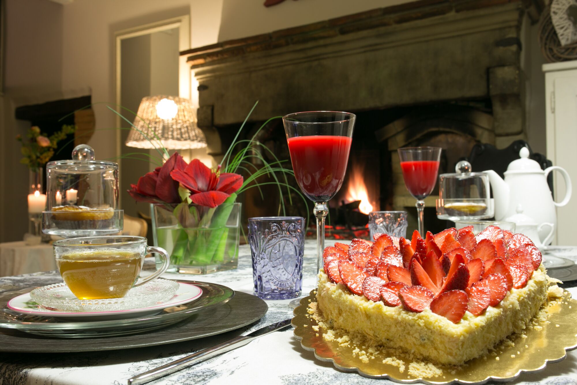 Een gedekte tafel met dessert, drankjes en een kaars.