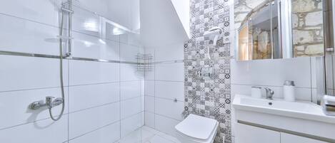 A modern bathroom with a shower, toilet, and sink.