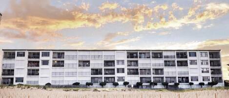 A multi-story building with a flat facade, numerous windows, and a uniform architectural style.