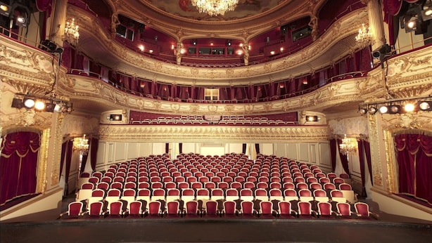 Ein prächtiges Theater mit mehreren Balkonen und Reihen roter Sitze.