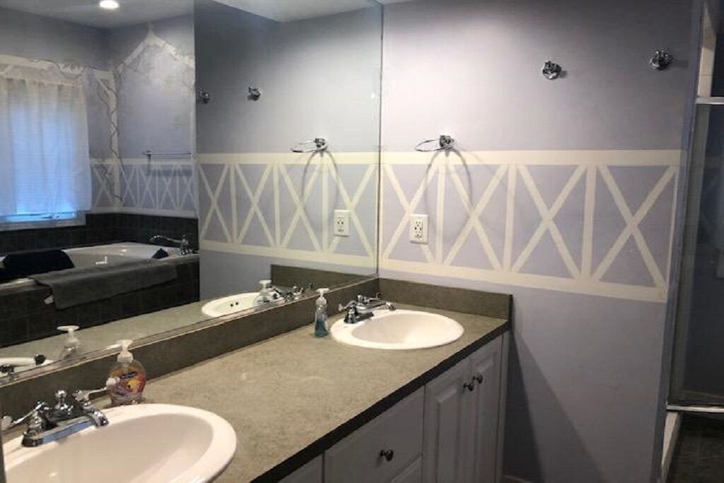 Un bagno con due lavandini, uno specchio grande e una vasca da bagno.