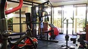 A gym with exercise equipment, including a treadmill and weights. - Lighthomez Pinnacle Suites (Nairobi)