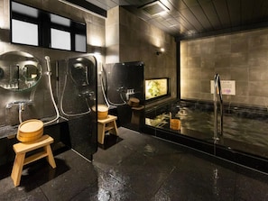 Casa de banho moderna com hidromassagem, banquinhos de madeira e um espelho.