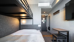 A hotel room with a bunk bed, a bedside table, a flat-screen TV, and an air conditioning unit. - Super Hotel Ikebukuro Nishiguchi (Tokyo)