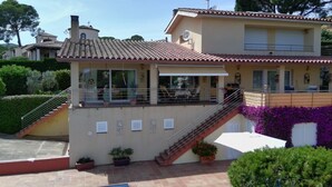 A two-story building with a tiled roof, a balcony, and a staircase leading to the upper floor. - Villa Urgell - L'Estartit, Torre Vella (Estartit (L´))
