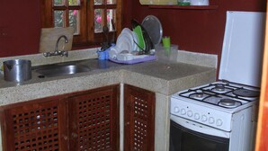 A kitchen with a sink, stove, and dish drying rack. - Lighthomez Villa Resort (Mombasa)