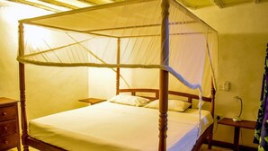 A four-poster bed with a canopy, wooden nightstands, and a bedside lamp. - Lighthomez Villa Resort (Mombasa)