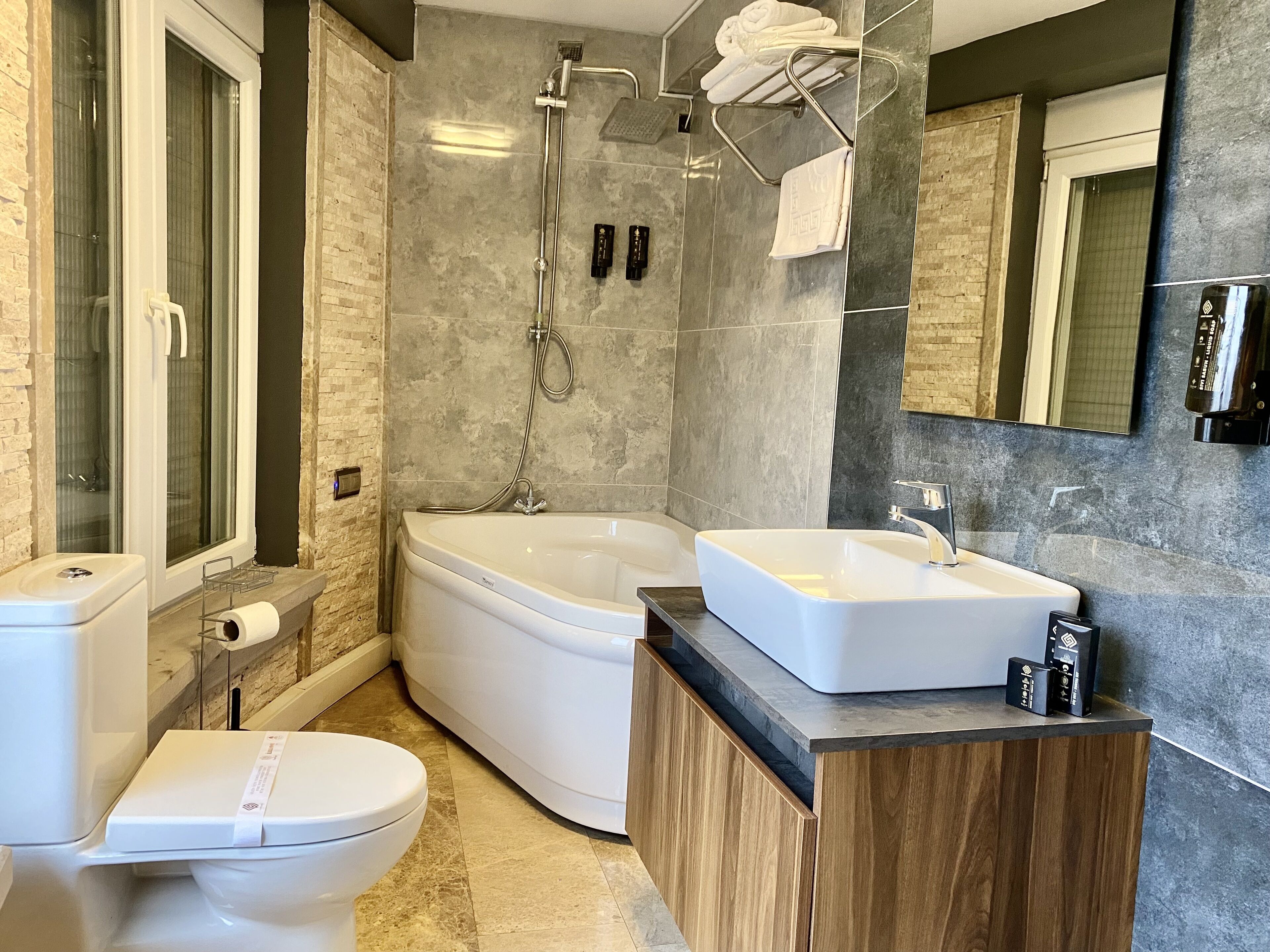 grand suite, bathtub, city view | bathroom | designer toiletries, hair dryer, slippers, towels