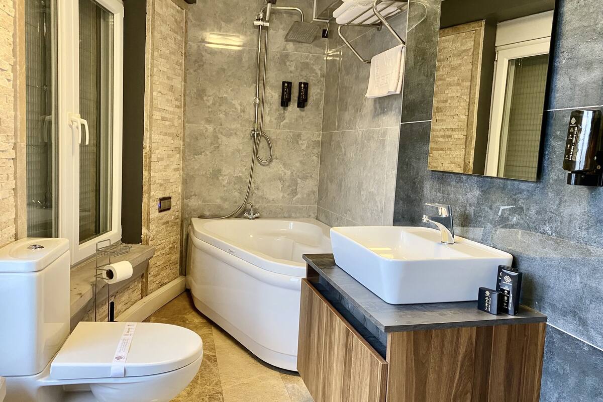 grand suite, bathtub, city view | bathroom | designer toiletries, hair dryer, slippers, towels