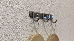 A wall-mounted metal rack with two wooden hangers attached to it. - Sun My Hotel (Davao)