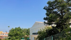Un sentiero acciottolato che conduce a un edificio con facciata bianca e un balcone.