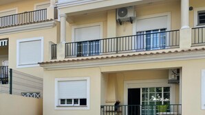 Un edificio residenziale con piscina, area relax all'aperto e un balcone.