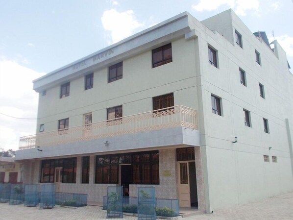 A multi-story building with a flat roof, large windows, and a balcony on the second floor. - Marvin Hotel (Nakuru)