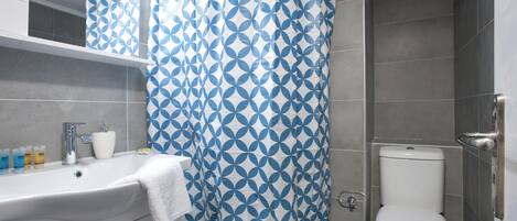 A bathroom with a white sink, a toilet, and a shower curtain with a geometric pattern.