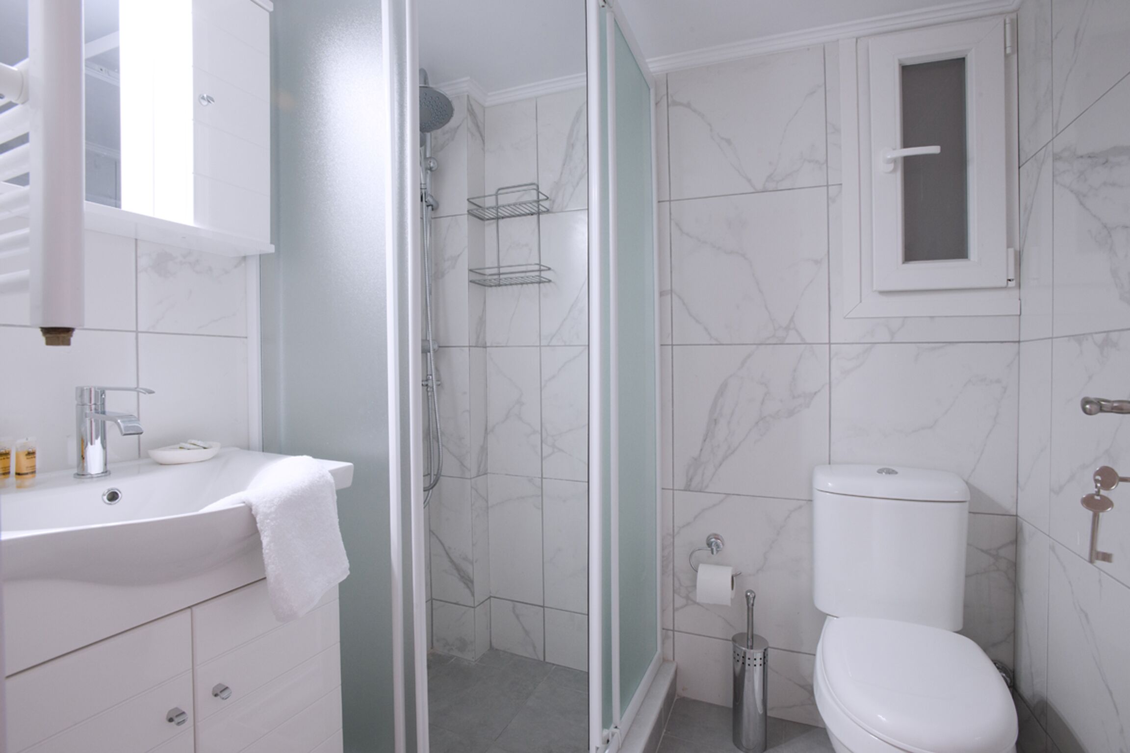 A bathroom with a sink, toilet, and shower.