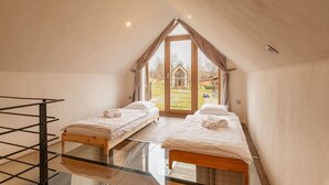 Una habitación con dos camas, piso de cristal y vista a un edificio.