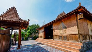 A traditional wooden building with a tiled roof and a small pavilion. - OYO 2327 Pagsis Village (Klaten)