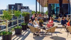 A rooftop patio with outdoor seating, potted plants, and a view of the cityscape. - Hotel Matts (Espoo)