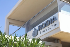 Ein Schild für 'RODIA Beach Suites' mit einem Logo über dem Schriftzug.