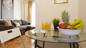 A modern living room with a glass table, a bowl of fruit, and a sofa. - Exarchia a nice and cozy apartment (Athens)