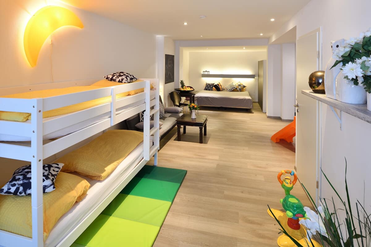 A modern bedroom with bunk beds, a bedside table, and a nightstand.