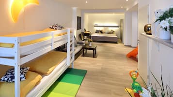 Ein modernes Schlafzimmer mit Etagenbetten, einem Nachttisch und einem Beistelltisch.
