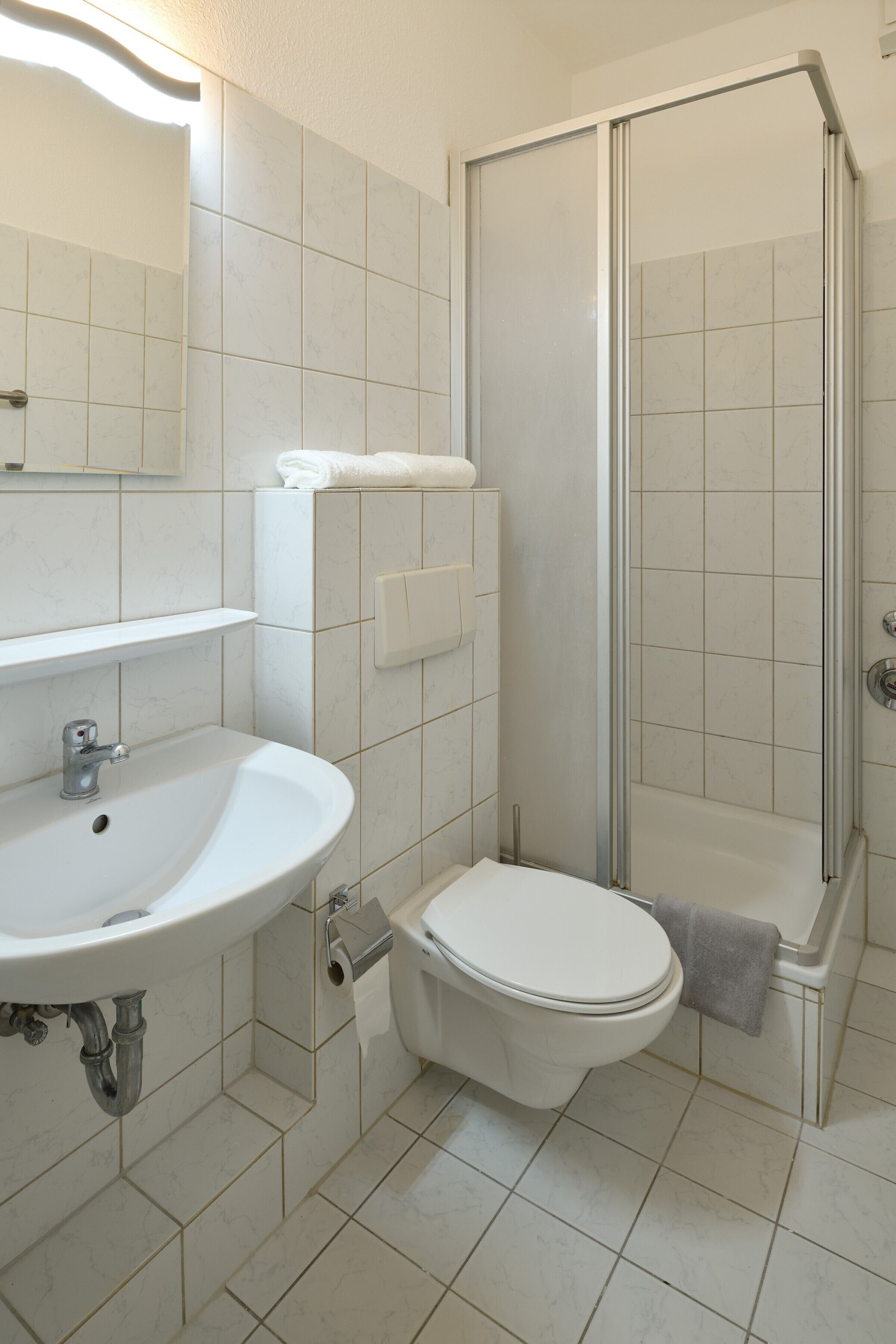A bathroom with a sink, toilet, and shower.