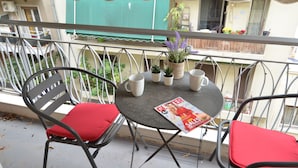 A balcony with a table, chairs, and a magazine. - Niovis a nice and cozy apartment (Athens)