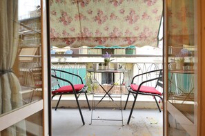 A balcony with two chairs and a small table, covered by a floral awning. - Niovis a nice and cozy apartment (Athens)